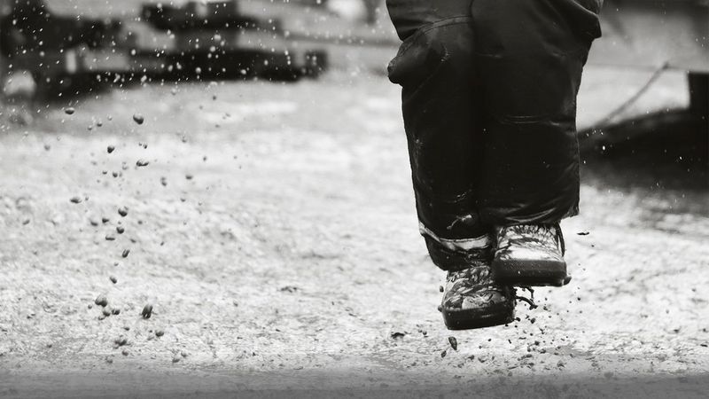A black and white shot of someone splashing in puddles, photographed by Hannah Clark on a Canon EOS 250D.